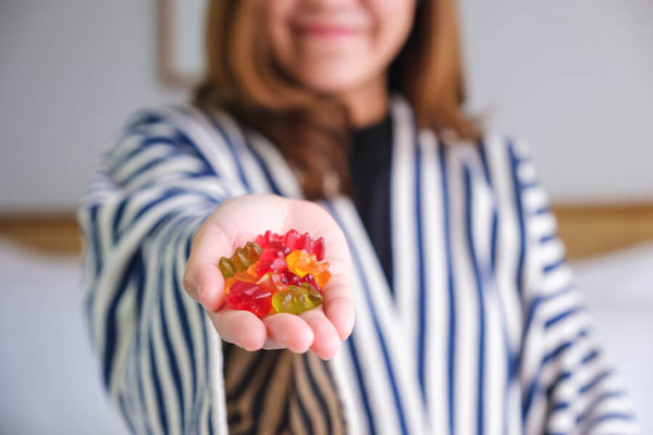 Creatina en gomitas para que sirve - Mujer sosteniendo bebida deportiva al aire libre