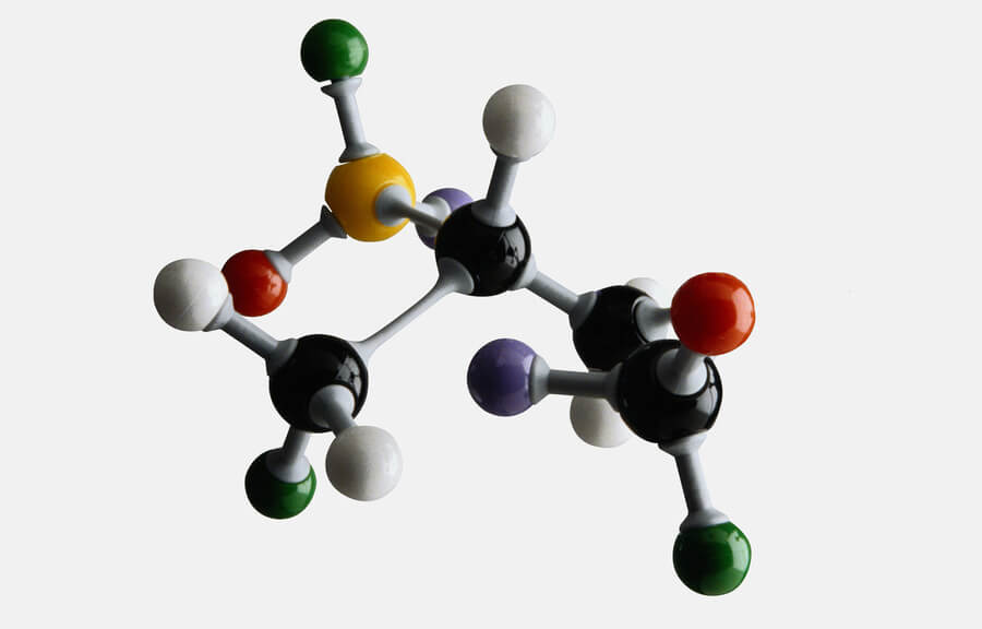 Modelo molecular con esferas de colores conectadas sobre fondo claro.