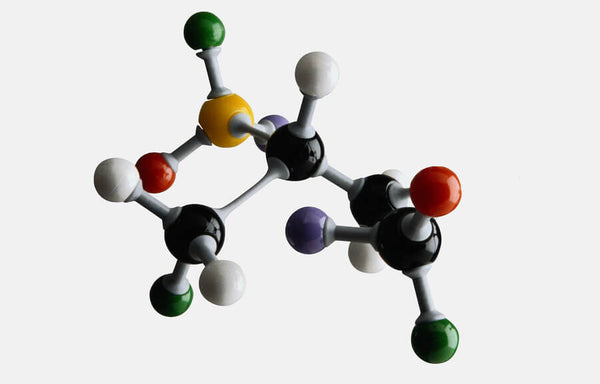 Modelo molecular con esferas de colores conectadas sobre fondo claro.