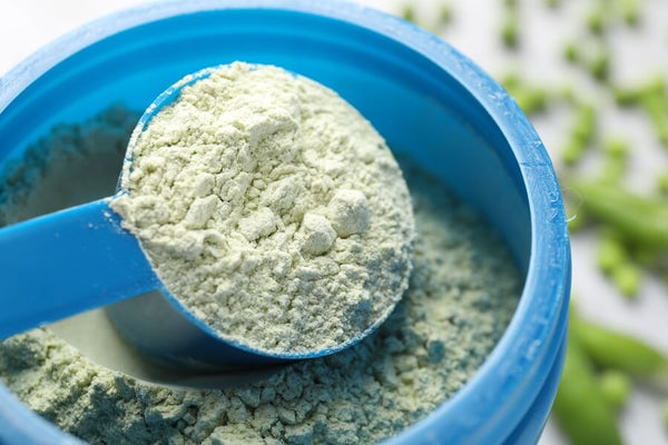 para que sirve la proteina vegana - Hombre estirando frente a un lago al atardecer