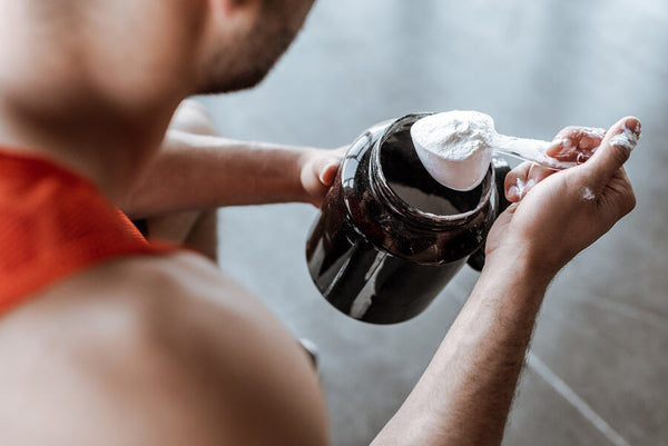 que es creatina hcl - Hombre preparando suplemento en el gimnasio