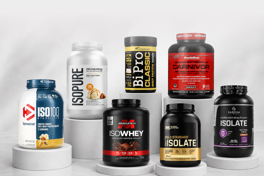 Proteinas Isolate - Proteínas en polvo de distintas marcas sobre pedestales blancos en fondo limpio.